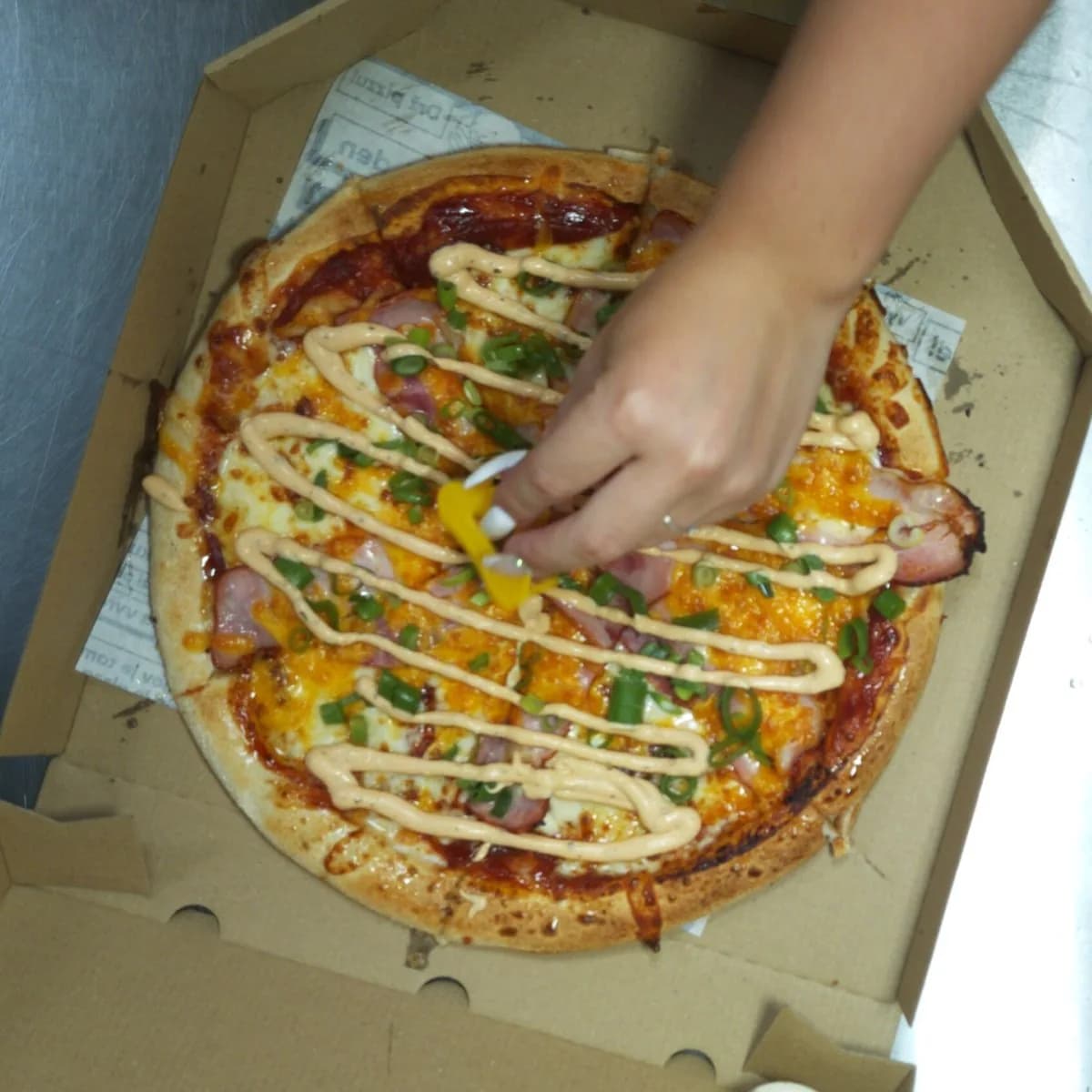 Pizza with a hand resting on it