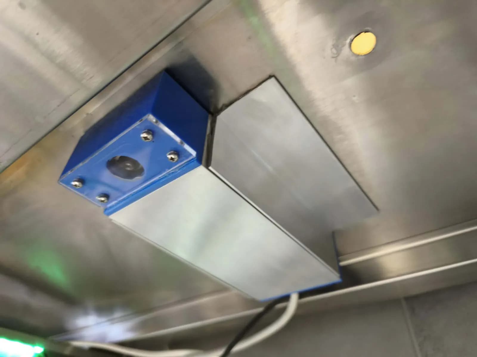 Pizza Checker camera mounted under the stainless shelf at a Vosíme packing station, with the green status light below