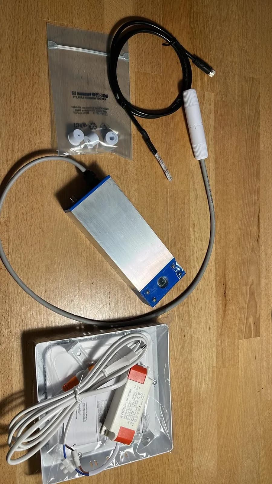The camera with its cable, a bag of fittings, and the LED panel laid out on a desk